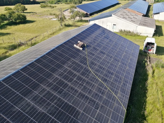 Un technicien effectuant un nettoyage des panneaux solaires pour maximiser leur efficacité. Le nettoyage régulier des panneaux solaires permet d’améliorer la production d’énergie et de prolonger la durée de vie de l’installation.